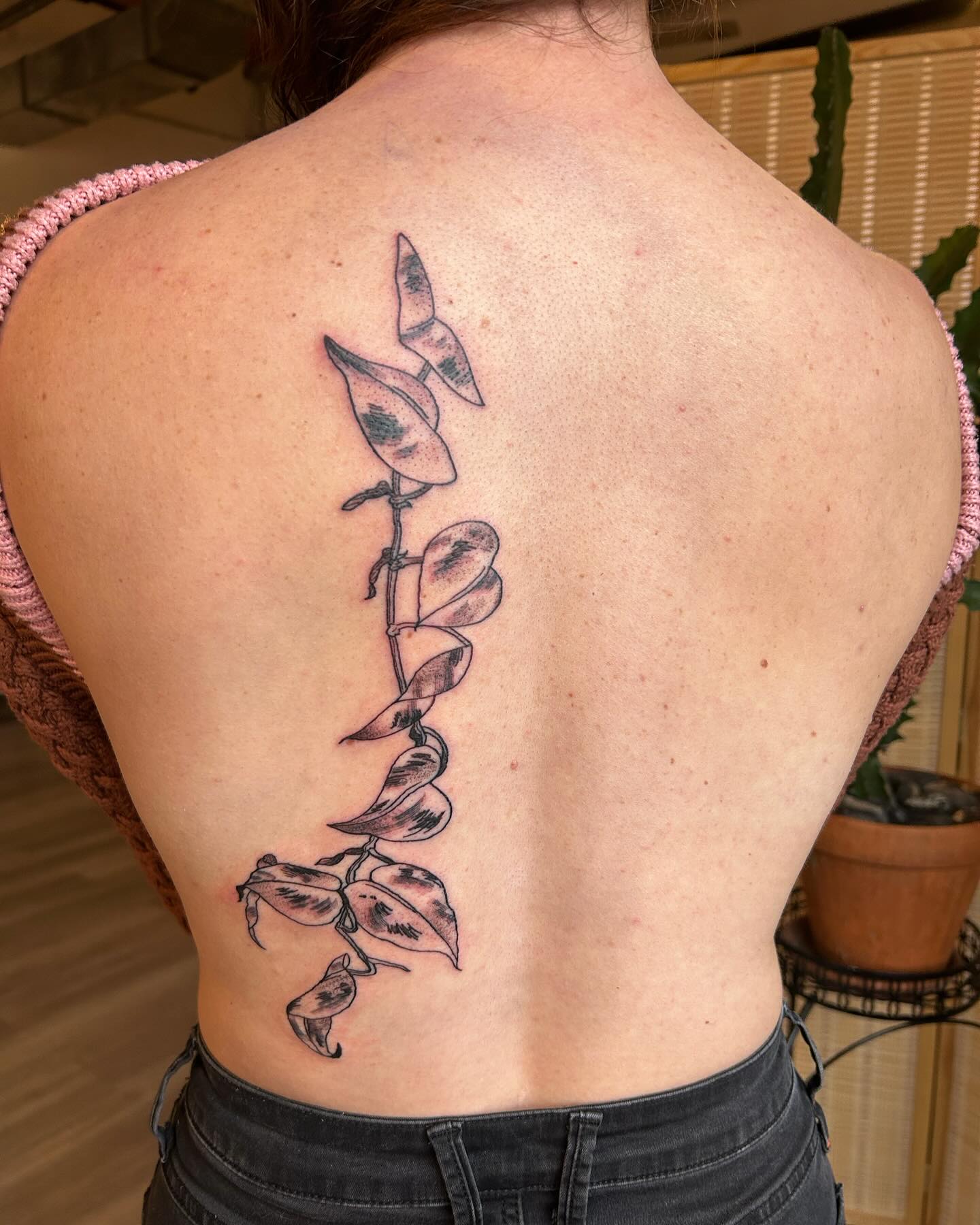 A leaf vine tattooed down the spine